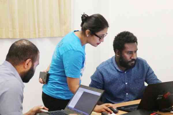EQAP’s Rukshar Khan, standing, guides Vanuatu Education Ministry’s IT manager Adrian Banga on the PacSIMS components, as her colleague Senitiki Rokocakau works nearby.